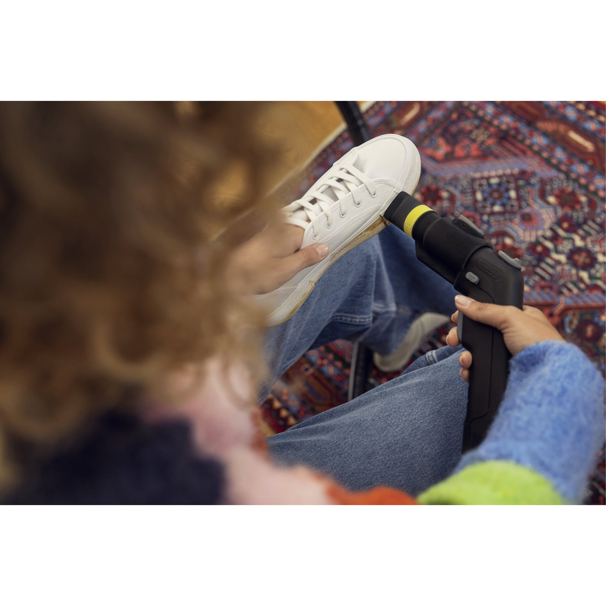 Schuhe, weiße Sneaker, Schnürsenkel, Schuhreinigungs-/Pflegegerät, Bild zeigt Fuß mit Gerät